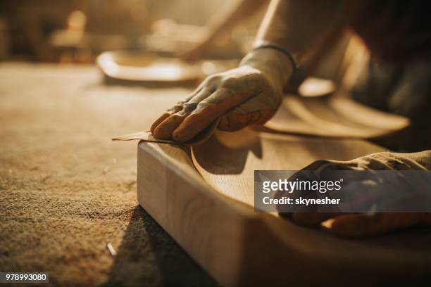 cerca de carpintero irreconocible restaurar una madera con papel de lija. - fabricantes de muebles de artesania fotografías e imágenes de stock