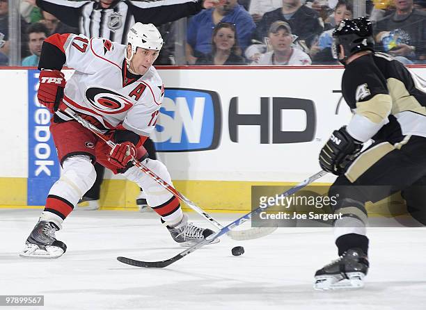 Rod Brind'Amour of the Carolina Hurricanes moves the puck up ice in front of Jordan Leopold of the Pittsburgh Penguins on March 20, 2010 at Mellon...