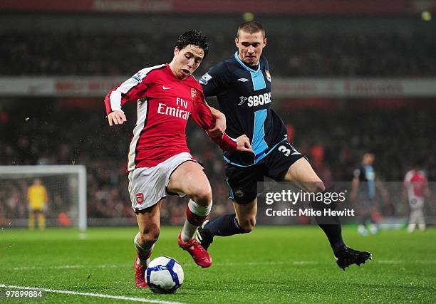 Samir Nasri of Arsenal is challenged by Fabio Daprela of West Ham United during the Barclays Premier League match between Arsenal and West Ham United...