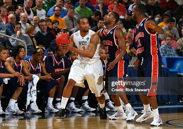 Da'Sean Butler of the West Virginia Mountaineers handles the ball against c and Reggie Holmes of the Morgan State Bears during the first round of the...