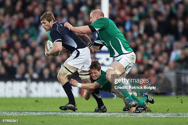 John Barclay of Scotland is tackled by Ronan O'Gara and Paul O'Connell of Ireland during the RBS Six Nations match between Ireland and Scotland at...