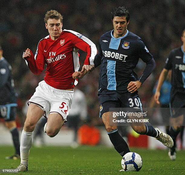 Arsenal's Danish striker Nicklas Bendtner vies with West Ham's English defender James Tomkins during the English Premier League football match...