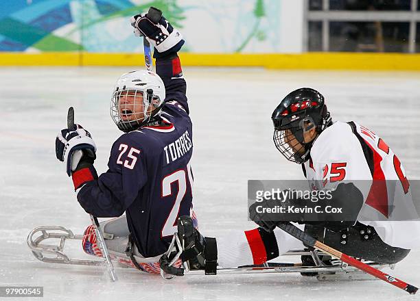 Bubba Torres of the United States cheers after a call is made while skating alongside Eiji Misawa of Japan during the first period of the Ice Sledge...
