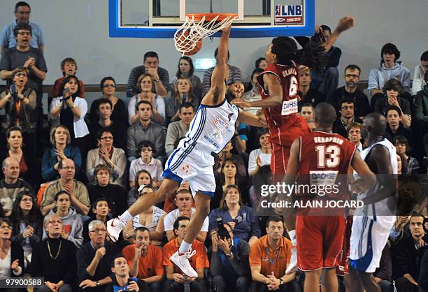 Poitiers' Tommy Gunn scores despite Cholet's Michael Gelabale during their French proA basketball match Poitiers vs Cholet on March 20, 2010 in...