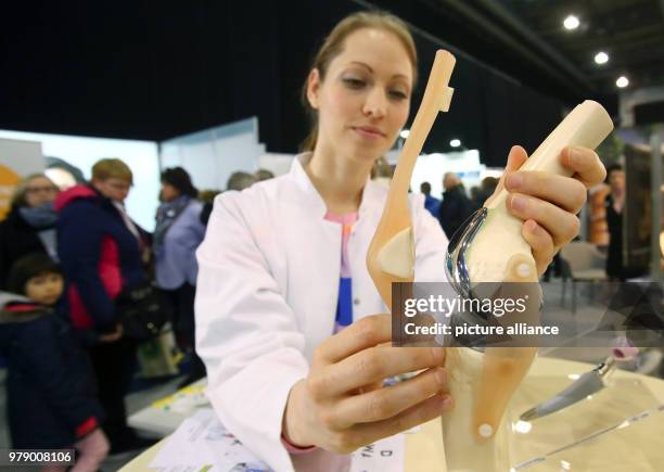March 2018, Germany, Erfurt: Linda Krakow of the hospital 'Waldkrankenhaus Eisenberg' presents a model of an artificial knee at the Health Fair in...