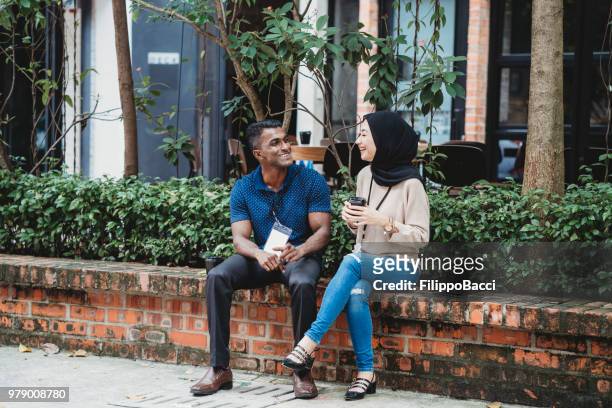 young adult couple taking a break from business during an event - employee badge stock pictures, royalty-free photos & images