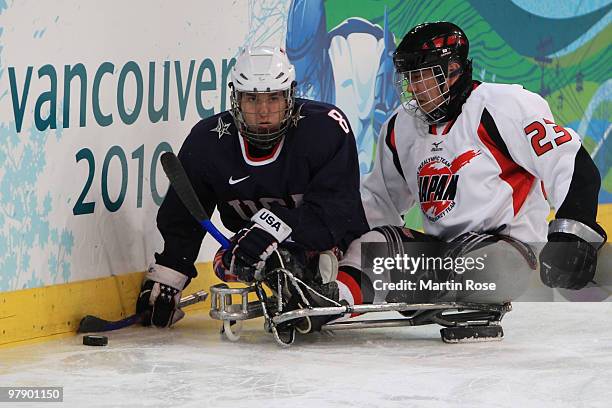 Greg Shaw of the United States looks to pass against Naohiko Ishida of Japan during the second period of the Ice Sledge Hockey Gold Medal Game on day...