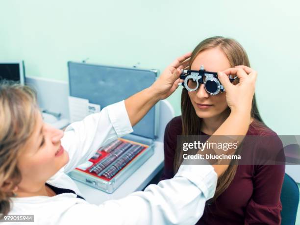 young woman having her eyes checked at ophthalmologist - astigmatism stock pictures, royalty-free photos & images