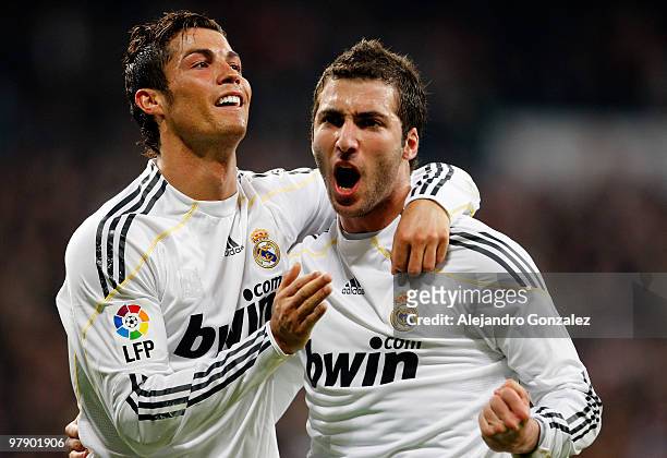 Gonzalo Higuain of Real Madrid celebrates with Cristiano Ronaldo after scoring during the La Liga match between Real Madrid and Sporting Gijon at...