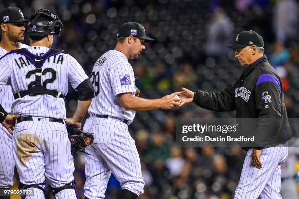 Bud Black of the Colorado Rockies relieves Bryan Shaw after Shaw loaded the bases with one out in the seventh inning of a game at Coors Field on June...