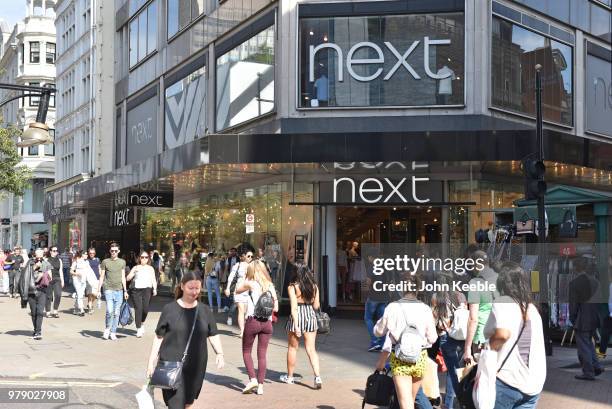 Shoppers walk past Next fashion retail shop on Oxford Street on June 11, 2018 in London, England.