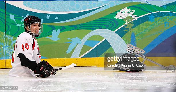 Takayuki Endo of Japan sits on the ice after getting knocked out of his sled against the United States during the Ice Sledge Hockey Gold Medal Game...