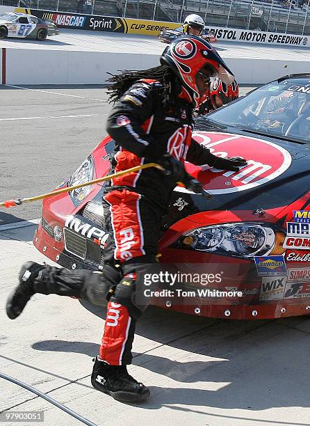 The front tire changer for the Rheem Chevrolet, driven by Kevin Harvick, runs around the car d pit stop the NASCAR Nationwide Series Scotts Turf...