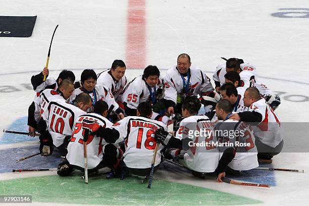 Team Japan celebrates their silver-medal win at center ice after being defeated 2-0 by the United States during the Ice Sledge Hockey Gold Medal Game...
