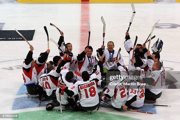 Team Japan celebrates their silver-medal win at center ice after being defeated 2-0 by the United States during the Ice Sledge Hockey Gold Medal Game...