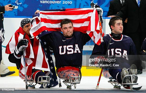 Joe Howard, Alexi Salamone and Adam Page of the United States celebrate their 2-0 win over Japan during the Ice Sledge Hockey Gold Medal Game between...