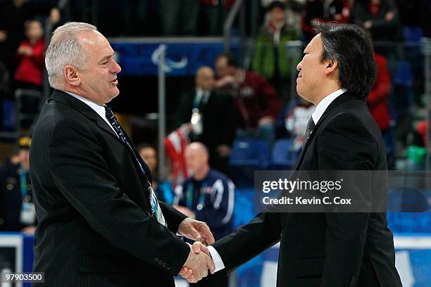 Ray Maluta, head coach of the United States, and Kojin Nakakita, head coach of Japan, shake hands after the United States defeated Japan 2-0 during...