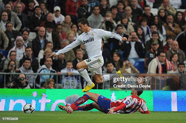 Cristiano Ronaldo of Real Madrid gets past Botia of Sporting Gijon during the La Liga match between Real Madrid and Sporting Gijon at Estadio...