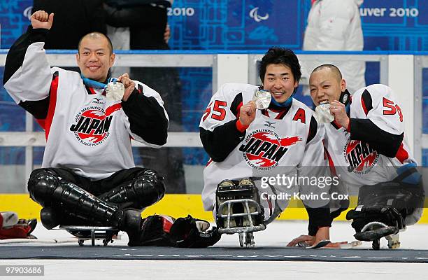 Goalkeeper Mitsuru Nagase, Kazuhiro Takahashi and Noritaka Ito of Japan celebrate their silver-medal win after being defeated 2-0 by the United...