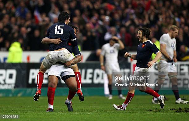 Clement Poitrenaud of France jumps into the arms of Mathieu Bastareaud as Marc Andreu celebrates the Grand Slam win during the RBS Six Nations...