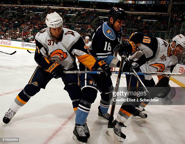 Nathan Horton of the Florida Panthers tangles with Matt Ellis of the Buffalo Sabres and teammate Henrik Tallinder at the BankAtlantic Center on March...