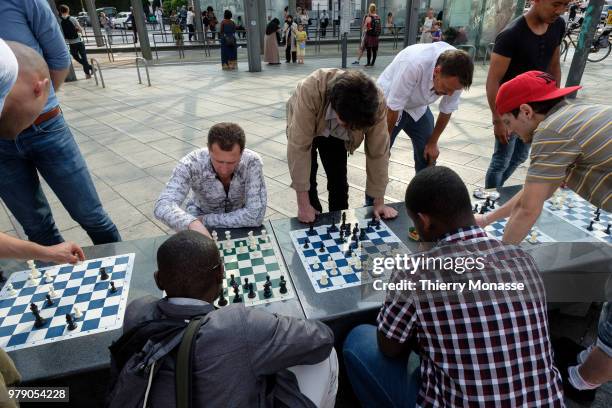 Men are playing chess in the Place Flagey.