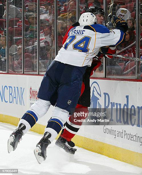 Oshie of the St. Louis Blues checks Colin White of the New Jersey Devils high and hard into the boards during the game at the Prudential Center on...