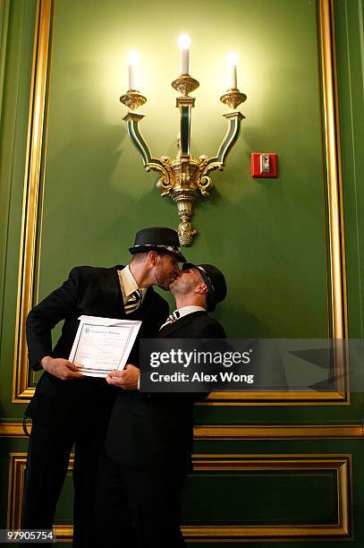 Same-sex couple and local residents Dalin Holyoak and Drew Parker exchange kisses as they receive their marriage certificate after a group wedding...
