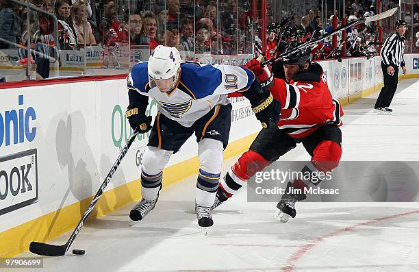 Andy McDonald of the St. Louis Blues skates against Brian Rolston of the New Jersey Devils at the Prudential Center on March 20, 2010 in Newark, New...