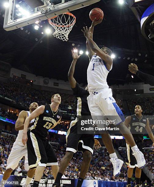 Darius Miller the Kentucky Wildcats shoots over the defense of Al-Farouq Aminu and Chas McFarland of the Wake Forest Demon Deacons during the second...