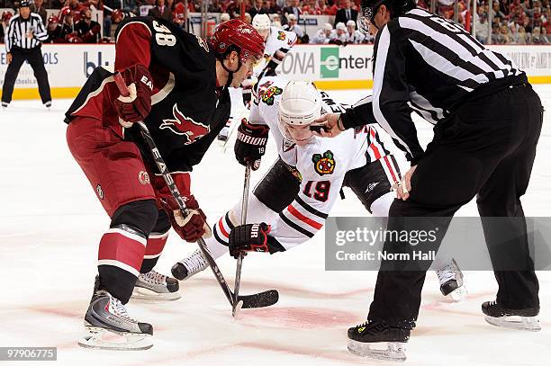 Vernon Fiddler of the Phoenix Coyotes and Jonathan Toews of the Chicago Blackhawks take a faceoff from Linesman Ryan Galloway on March 20, 2010 at...