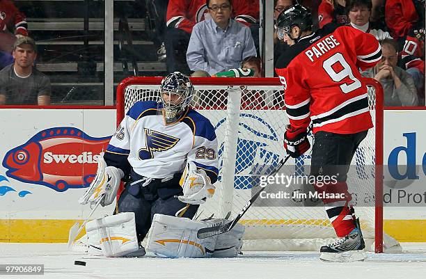 Ty Conklin of the St. Louis Blues defends his net against Zach Parise of the New Jersey Devils at the Prudential Center on March 20, 2010 in Newark,...