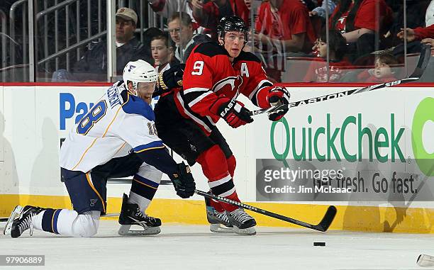 Jay McClement of the St. Louis Blues battles for the puck against Zach Parise of the New Jersey Devils at the Prudential Center on March 20, 2010 in...