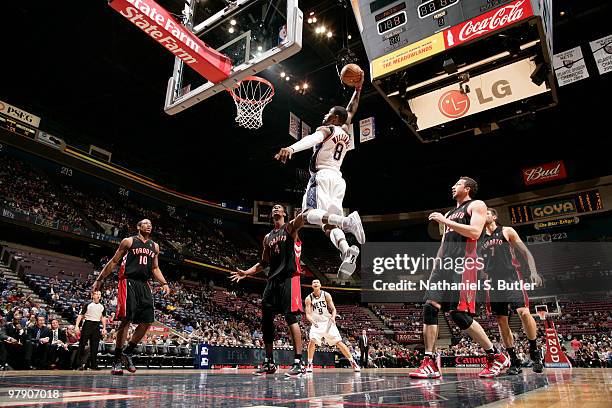 Terrence Williams of the New Jersey Nets dunks against Chris Bosh of the Toronto Raptors on March 20, 2010 at the IZOD Center in East Rutherford, New...