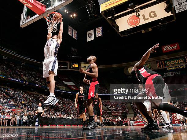 Kris Humphries of the New Jersey Nets dunks against Jarrett Jack of the Toronto Raptors on March 20, 2010 at the IZOD Center in East Rutherford, New...