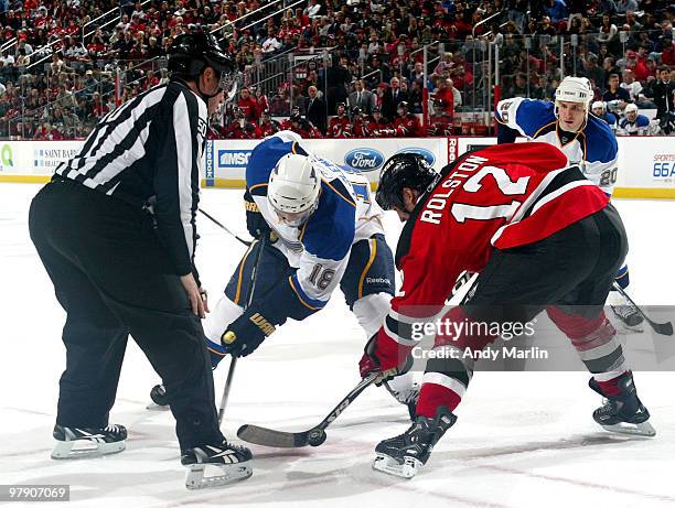 Linesman Scott Cherry drops the puck on a faceoff between Jay McClement of the St. Louis Blues and Brian Rolston of the New Jersey Devils during the...