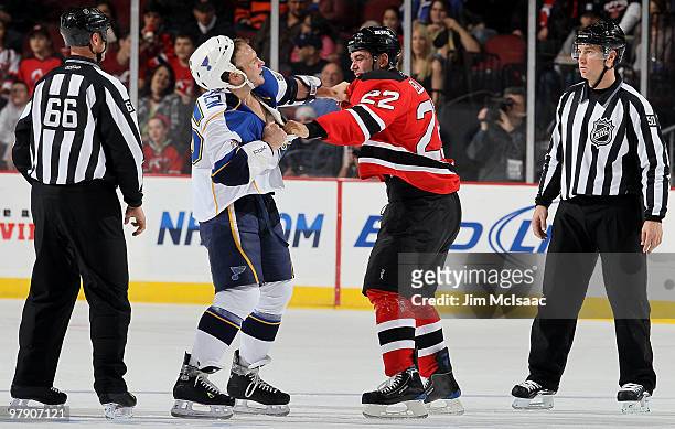 Cam Janssen of the St. Louis Blues trades punches with Pierre-Luc Letourneau-Leblond of the New Jersey Devils during their first period fight as...