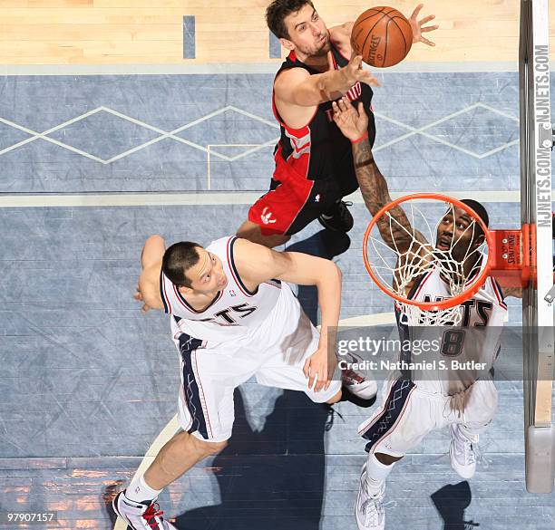 Jose Calderon of the Toronto Raptors reaches for the ball over Terrence Williams and Yi Jianlian of the New Jersey Nets on March 20, 2010 at the IZOD...