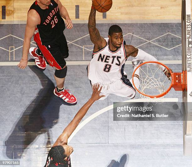 Terrence Williams of the New Jersey Nets dunks against Chris Bosh of the Toronto Raptors on March 20, 2010 at the IZOD Center in East Rutherford, New...