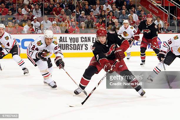 Radim Vrbata of the Phoenix Coyotes skates the puck up the ice against a defending Nick Boynton of the Chicago Blackhawks on March 20, 2010 at...