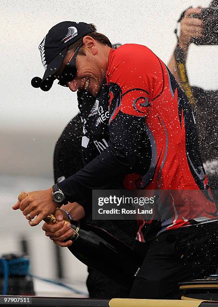 Emirates Team New Zealand skipper Dean Barker sprays Champagne after crossing the line ahead of Mascalzone Latino Audi Team from Italy to win the...