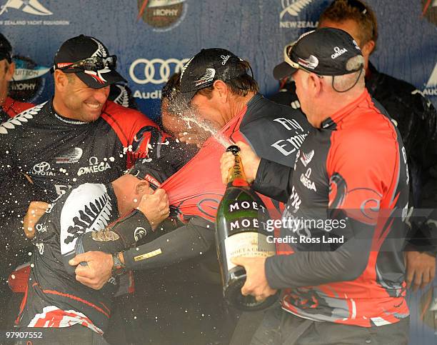 Emirates Team New Zealand member Don Cowie sprays Champagne during the trophy presentation after their teams win over Mascalzone Latino Audi Team...