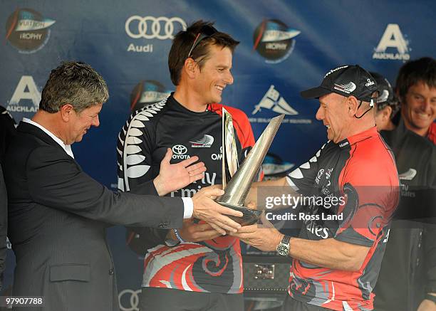 Emirates Team New Zealand CEO Grant Dalton and Skipper Dean Barker are presented with the trophy by Louis Vuitton CEO Yves Carsell at the trophy...