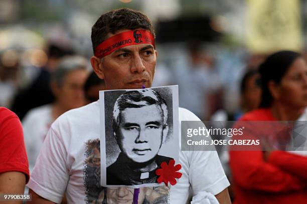 Catholic faithful holds a picture of a Catholic priest killed during the Salvadorean civil war during a procession to conmemorate the 30 anniversary...