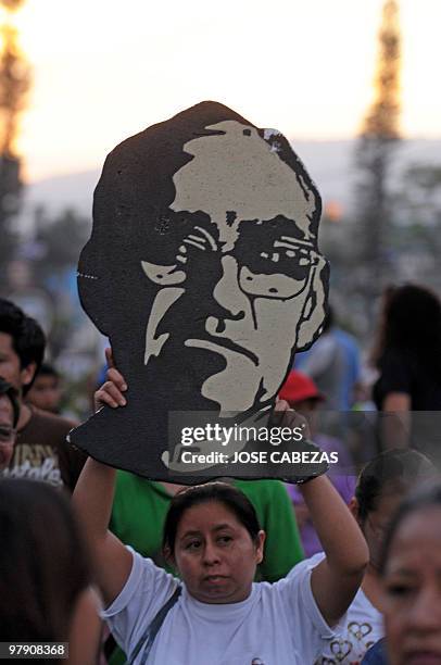 Catholic faithfuls holds a cutout of Archbishop Oscar Arnulfo Romero during a procession to conmemorate the 30 anniversary of the murder of...