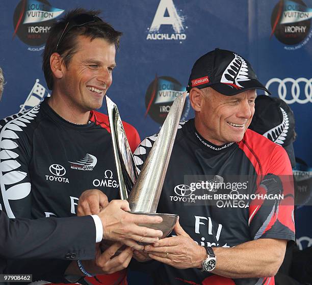 Team New Zealand's Dean Barker and Grant Dalton hold their trophy following the finals of the Louis Vuitton sailing trophy in Auckland on March 21,...