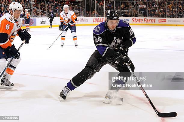 Alexander Frolov of the Los Angeles Kings skates with the puck ahead of Bruno Gervais of the New York Islanders at Staples Center on March 20, 2010...