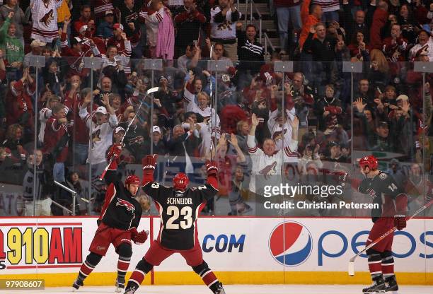 Adrian Aucoin of the Phoenix Coyotes celebrates with teammates Mathieu Schneider and Taylor Pyatt after Aucoin scored the game tying goal during the...