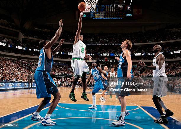 Rajon Rondo of the Boston Celtics goes in for the layup against Brendan Haywood and Dirk Nowitzki of the Dallas Mavericks during a game at the...