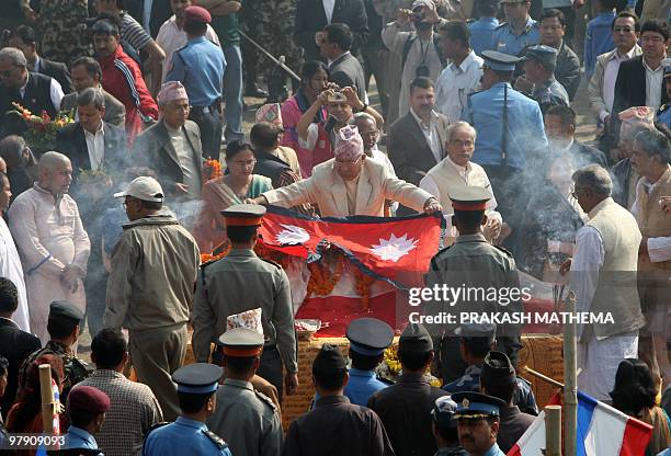 Nepal's Prime Minister Madhav Kumar Nepal lays the national flag over the body of Girija Prasad Koirala in Kathmandu on March 21, 2010. Koirala, who...